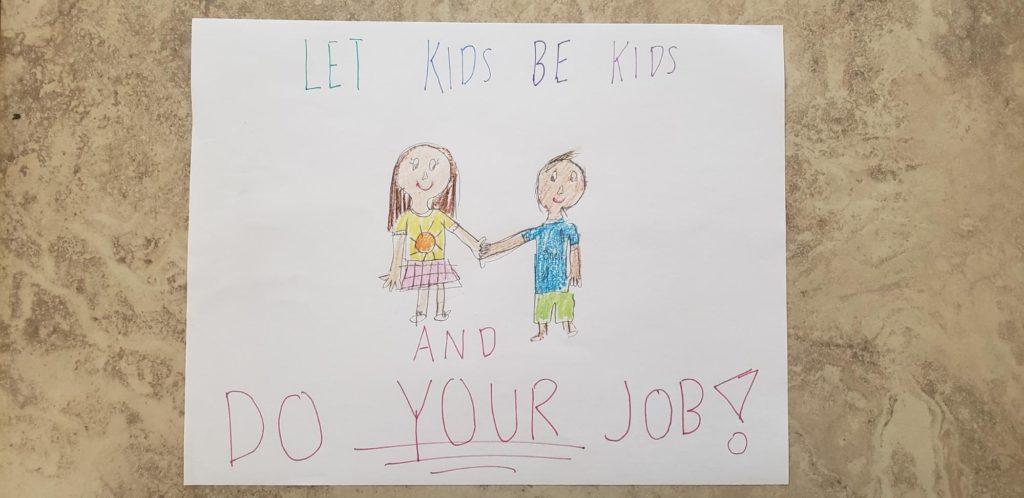 Drawing of two kids holding hands by Camilia (10 years) says "Let kids be kids and do your job!"