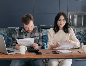 Two people look at their bills at the table